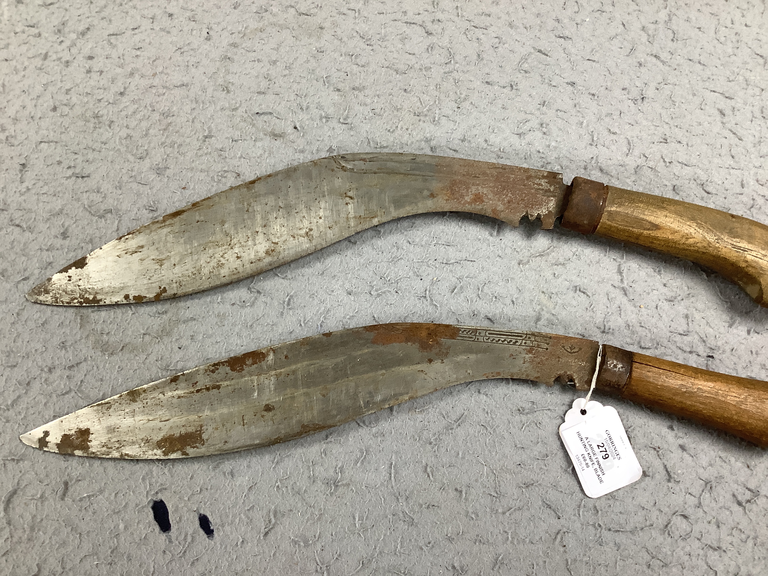 A large Finnish hunting knife, blade dated 1940 and burr wooden handle in its leather sheath, and two Indian kukri in their sheaths